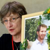 Martha Savage holds a portrait of her son, Kelly, who died after being forcibly restrained at a psychiatric hospital in Kanagawa Prefecture in May, during a news conference in Tokyo on Wednesday. Citizens group calls for review on use of restraints after New Zealand teacher’s death