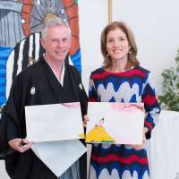 Well played: Peter MacMillan presents a specially made image of poem cards, featuring the Kennedy family tartan check in the costume of the poet, to Ambassador Caroline Kennedy at the U.S. Embassy in Tokyo in January. The sheer poetry of the world's first English-language 'karuta' game