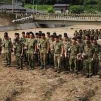 Self-Defense Forces solders hold a minute’s silence for victims prior to beginning search operations in a flooded area of Asakura, Fukuoka Prefecture, on Wednesday, two weeks after heavy rains and flooding in Kyushu. Prime Minister Shinzo Abe’s hope of enshrining the constitutionality of the SDF in the nation’s top law is looking increasingly difficult to achieve as his support drops. A reset for Abe's constitutional revision agenda?