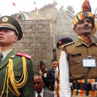 A Chinese soldier and an Indian soldier maintain ceremonial positions marking the borders of their respective countries at the 2006 opening of the Nathu La pass in the northeastern Indian state of Sikkim, which had been closed following military clashes between China and India in 1967. Border tensions are rising once again between the two Asian giants. Asia's colossus threatens a tiny state