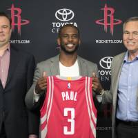 Chris Paul holds his new uniform with Rockets GM Daryl Morey (left) and coach Mike D’Antoni at a news conference on Friday in Houston. Paul hopes his teaming up with Harden fuels Rockets