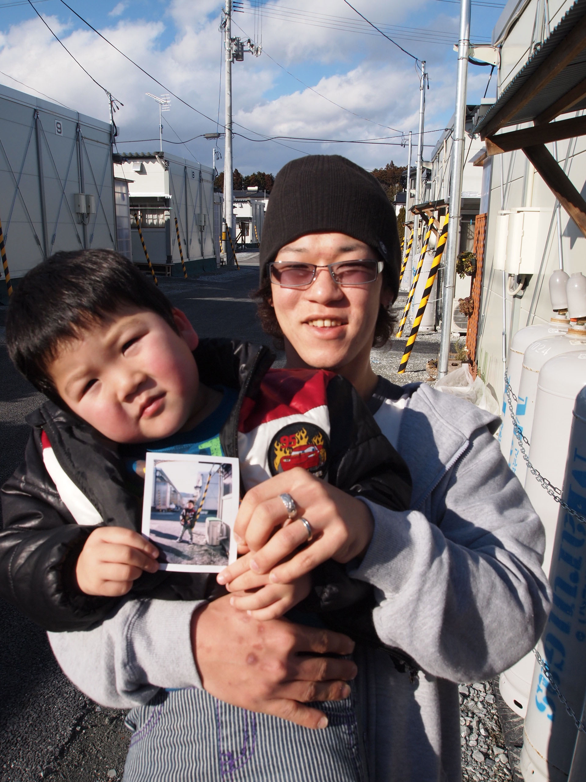 Memory bank: Proud father Tomohiro Nagakura shows off his son, Yushin, and a photo given to him by Photohoku at the Hirobata Temporary Housing Complex in Shinchi, Fukushima Prefecture. | JON MITCHELL PHOTOS