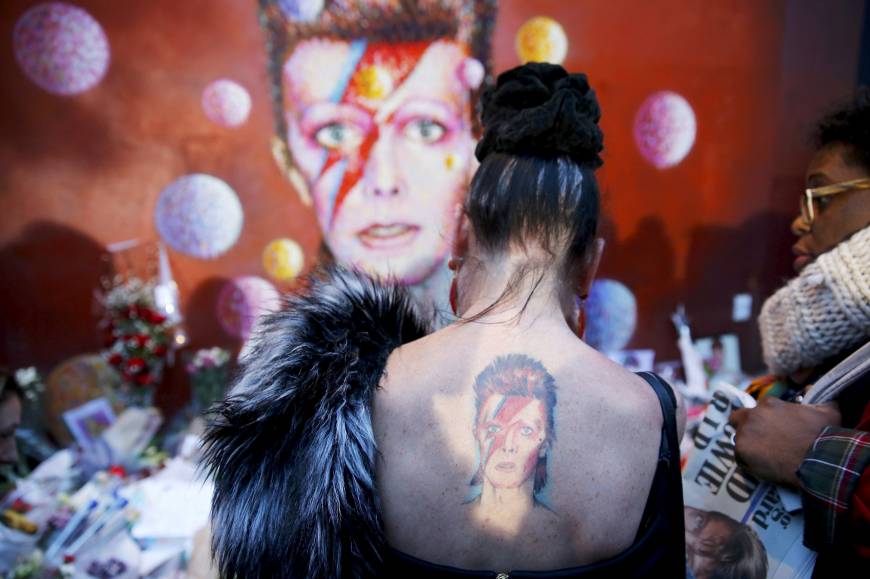 A woman with a Ziggy Stardust tattoo gets emotional as she visits the same mural.