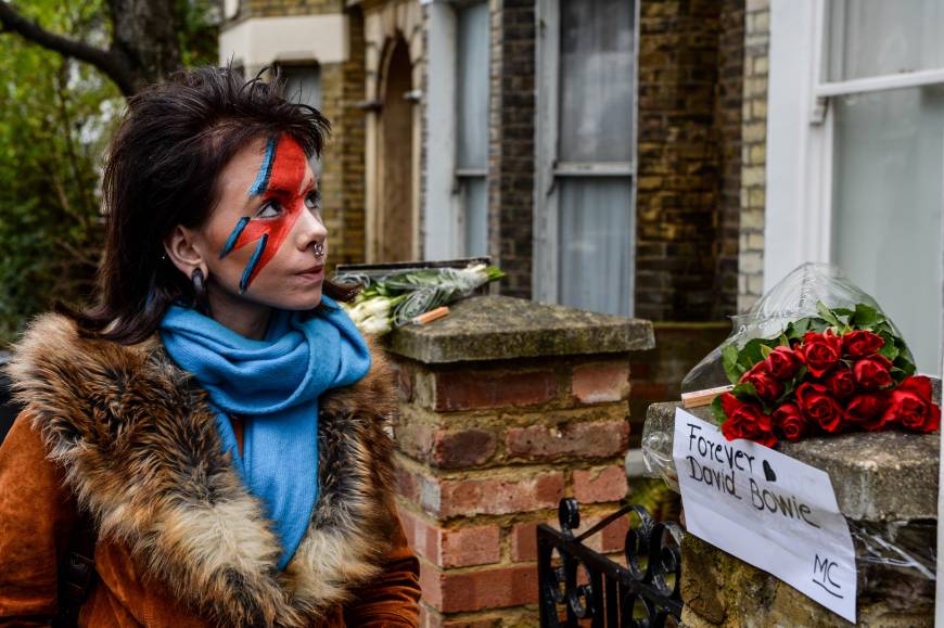 Another woman with her face painted like Ziggy Stardust pays her respects outside a house believed to be the childhood home of David Bowie in Brixton, south London.