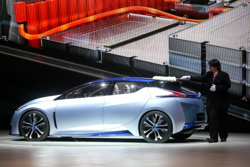 A worker cleans a Nissan IDS concept automobile, produced by Nissan Motor Co., on the second day of the 86th Geneva International Motor Show.