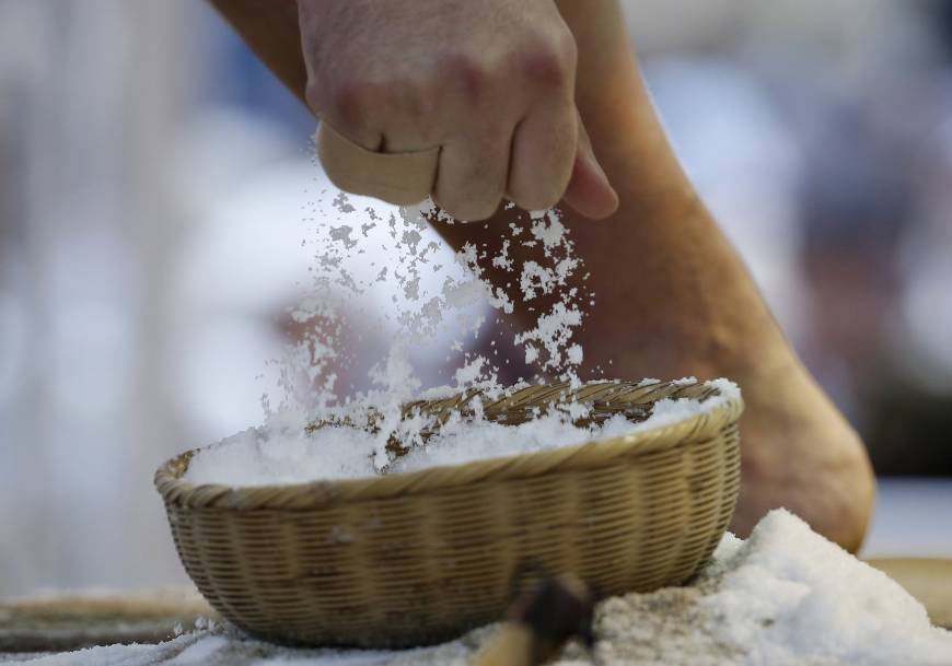 A sumo wrestler grabs a handfull of salt before competing in a Honzumo bout on Monday at Yasukuni Shrine.