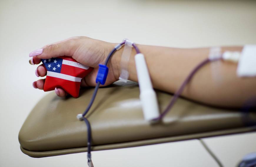 Tatiana Osorio, of Orlando, Florida, squeezes an American-flagged themed stress ball while giving blood at the OneBlood blood center near the nightclub Pulse.