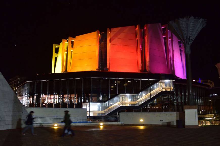 The Michael Fowler Centre lit up in rainbow colors in Wellington, New Zealand.