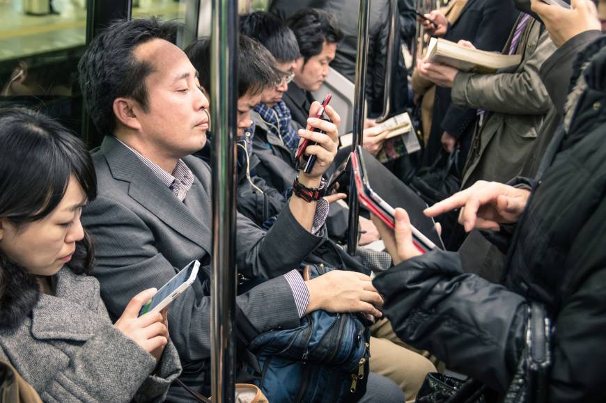 Communication cues: Commuters use smartphones and tablets in an underground train in March 2015.