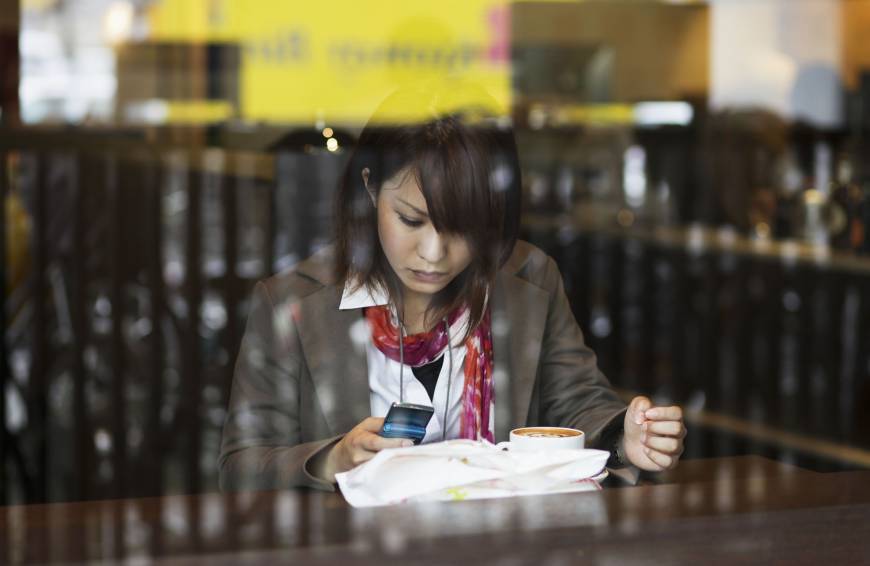 Spoiled for choice: A woman in a cafe sends a text message in Tokyo in May 2010.