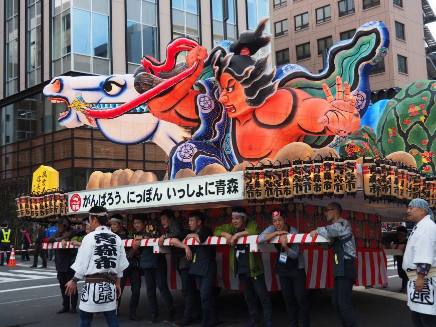 Men take a break before pushing a large Aomori Nebuta float down Shintora Street. While there are other nebuta festivals in Japan, Aomori