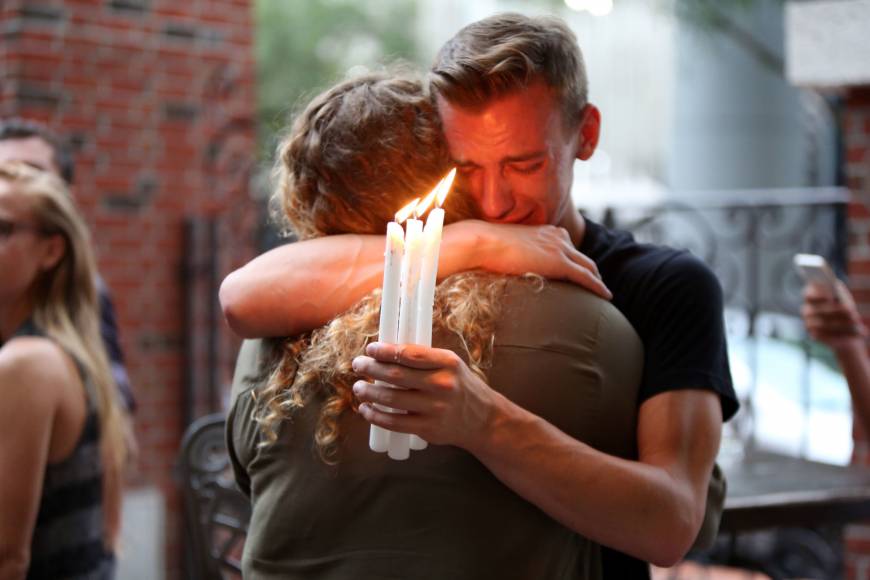 Brett Morian hugs a woman at a candlelight vigil in Orlando, Florida, following a mass shooting at the Pulse gay nightclub.
