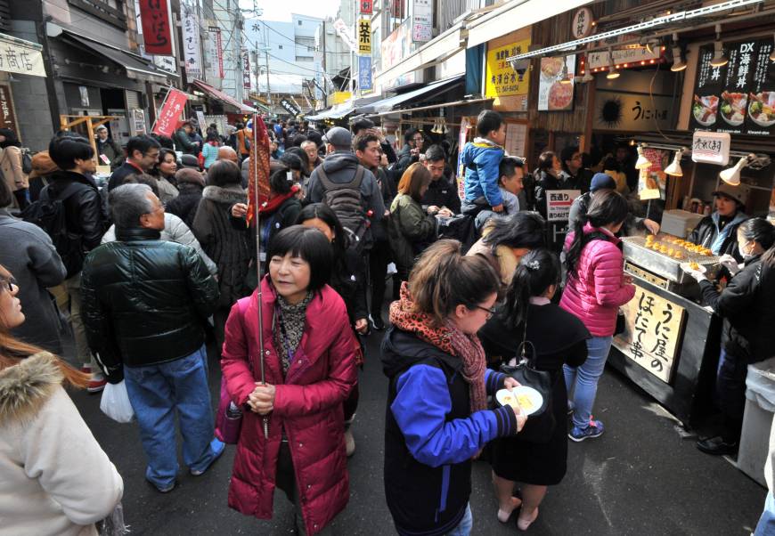 The shops and food stalls in the Tsukiji outer market are packed with tourists on Jan. 19.