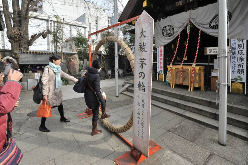 Visitors to Namiyoke Inari Shrine in Tsukiji, Tokyo, pass through a hoop made of grass that is believed to purify their spirits.