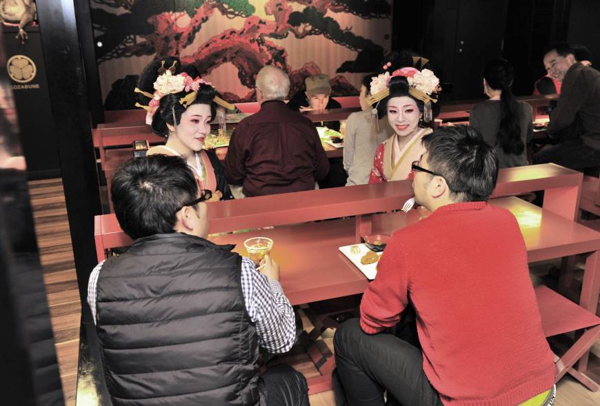 Foreign tourists enjoy food and drinks while conversing with 