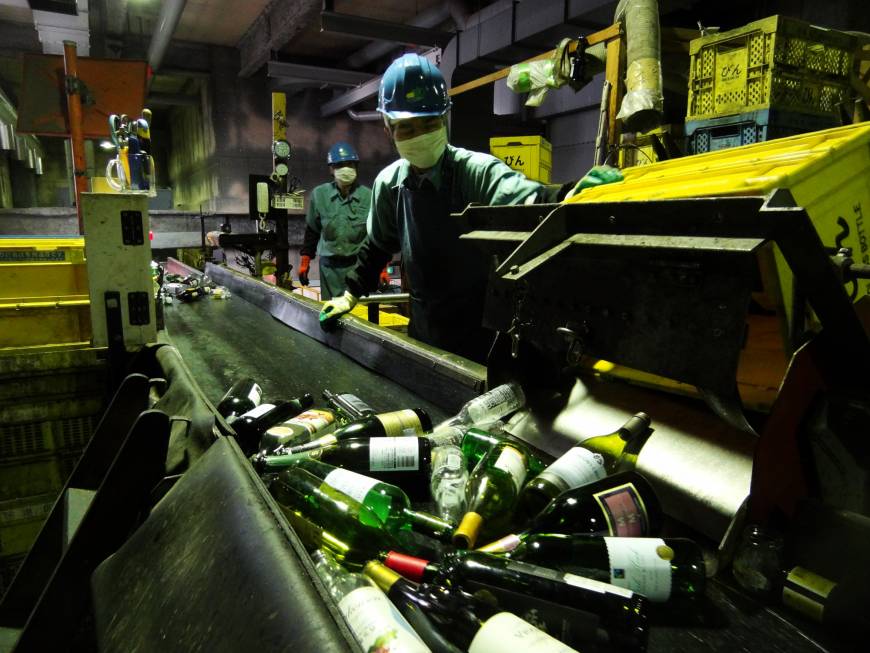 Crates of bottles are emptied onto a conveyor belt at the Minato Resource Recycle Center in Tokyo.