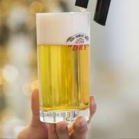 A bartender pours a glass of Asahi Super Dry beer. Asahi Group Holdings plans to sell its first bond in euros, following a &#36;10 billion buying binge in Europe during the past year. | BLOOMBERG