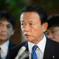 Taro Aso, deputy prime minister and finance minister, speaks to the media at the prime minister\'s residence in Tokyo on Tuesday. | BLOOMBERG