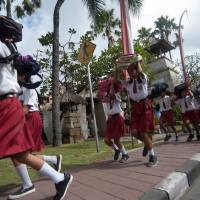 Pupils protect their heads as they run to a safe place during a tsunami drill at Tanjung Benoa school in Badung, Indonesia\'s Bali resort island, Tuesday. | ANTARA FOTO / NYOMAN BUDHIANA / VIA REUTERS
