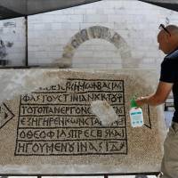 A conservationist works on a 1500-year-old mosaic floor bearing Greek writing, discovered near Damascus Gate in Jerusalem\'s Old City, as it is displayed at the Rockefeller Museum in Jerusalem on Wednesday. | REUTERS
