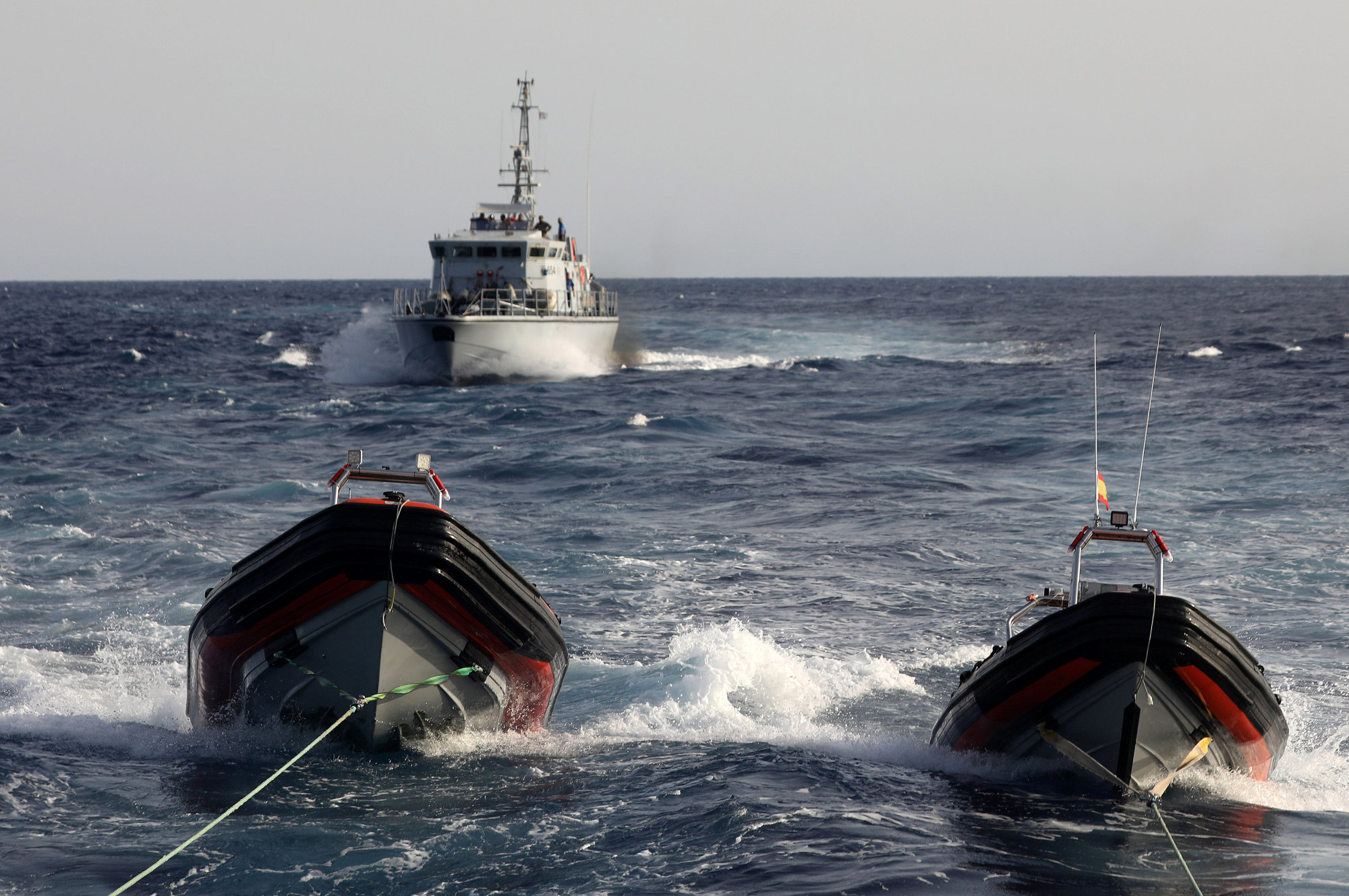 A Libyan coast guard vessel chases away the former fishing trawler Golf Azzurro of the Proactiva Open Arms rescue charity in the Western Mediterranean Sea Tuesday. | REUTERS