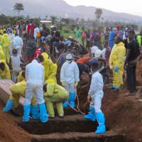 Victims of a mudslide are buried at the cemetery of Freetown on Thursday. Sierra Leone buried at least 300 victims of devastating floods, as fears grew of more mudslides and accusations of government \"inaction\" over deforestation and poor urban planning mounted. | AFP-JIJI
