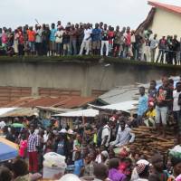 Mourners look on as victims of a mudslide are buried at the cemetery of Freetown on Thursday. | AFP-JIJI