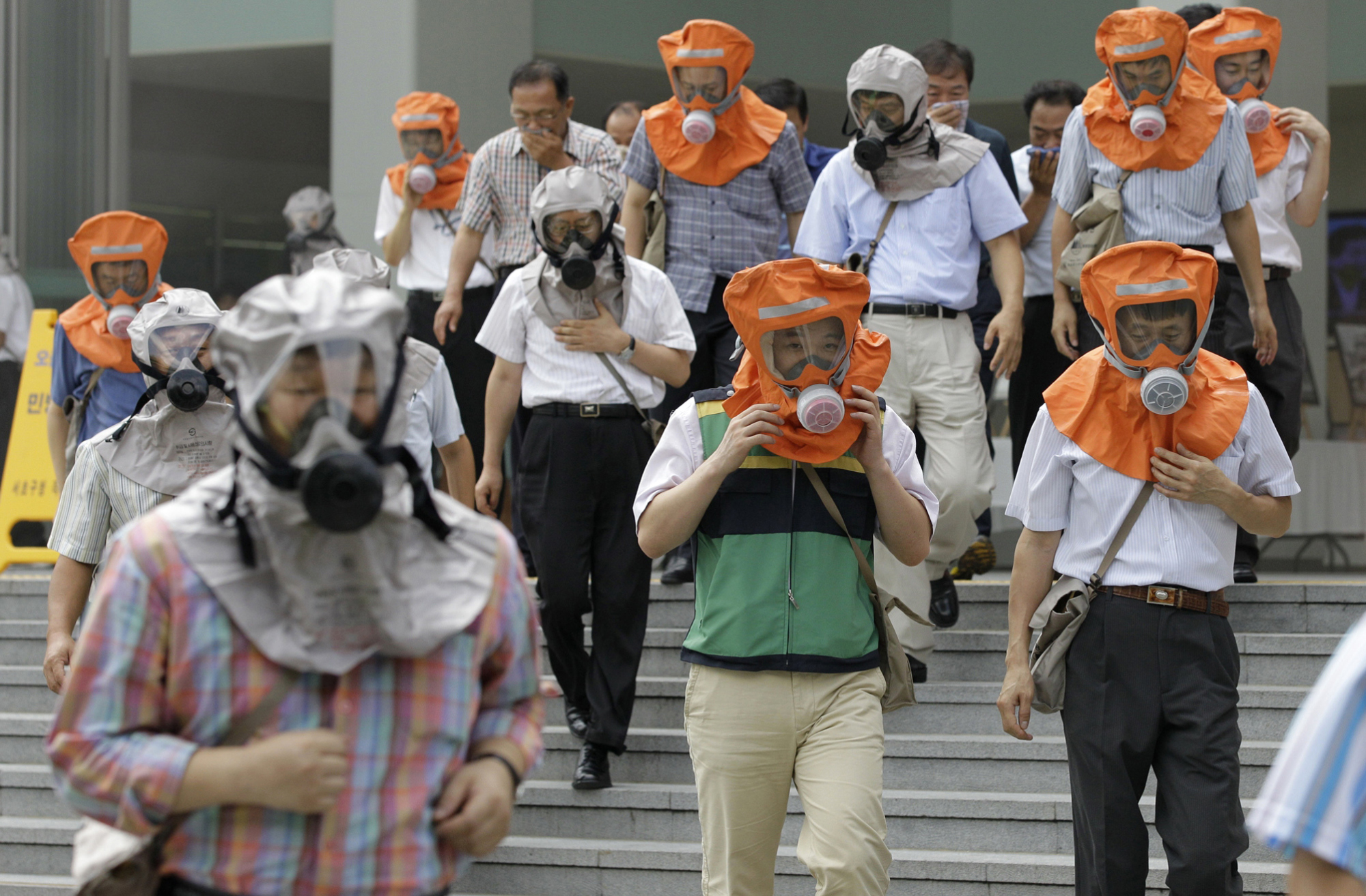 South Koreans wearing gas masks flee a mock attack as part of the Ulchi Freedom Guardian exercises in Seoul in August 2010. | AP