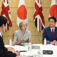 British Prime Minister Theresa May speaks while Prime Minister Shinzo Abe looks on during a meeting of Japan\'s National Security Council at Abe\'s official residence in Tokyo on Thursday. | REUTERS