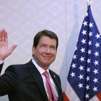 New U.S. Ambassador to Japan William Hagerty waves during a news conference on his arrival at Narita International Airport on Thursday. | AP