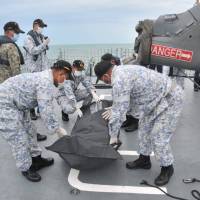 Royal Malaysian Navy personnel carry a body onto their ship during a search and rescue operation for survivors of the USS John S. McCain ship collision in this undated photo released Tuesday. | REUTERS