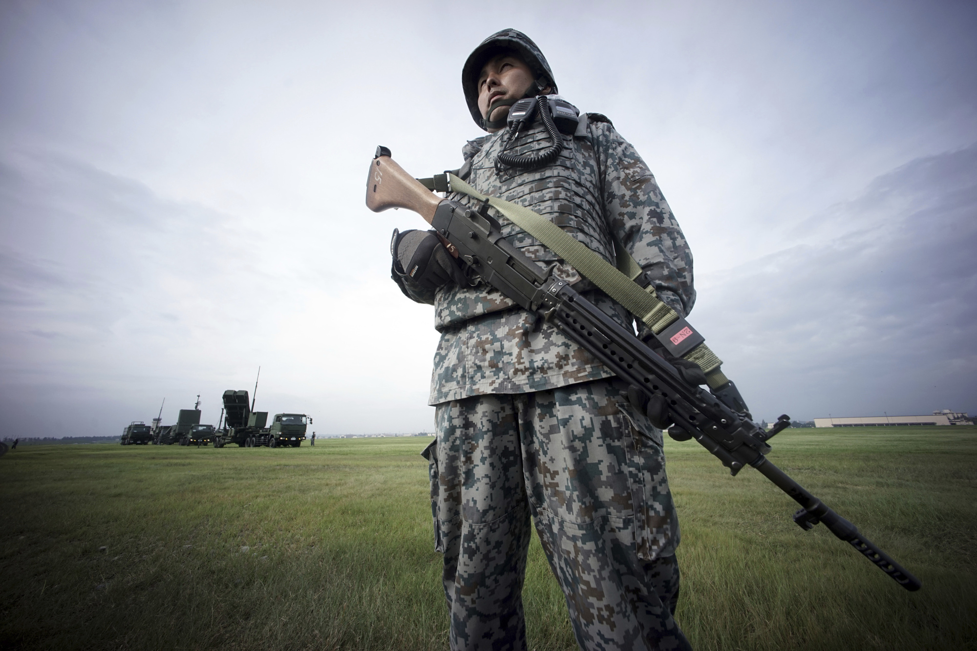 An Air Self-Defense Force member stands guard as the ASDF demonstrates the training to utilize the PAC-3 surface to air interceptors at the U.S. Yokota Air Base in Fussa, on the outskirts of Tokyo, on Tuesday. | AP