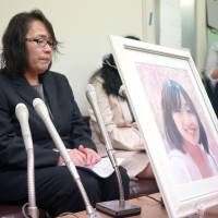 Mayumi Morishita holds a news conference Tuesday in Fukuoka after filing a lawsuit asking that the suicide of her daughter, Kana, be covered by workers\' compensation. | KYODO