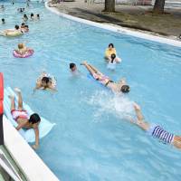 People swim in a pool at the Toshimaen amusement facility in Tokyo\'s Nerima Ward last week. KYODO | BANGLADESH COAST GUARD HANDOUT / VIA AFP-JIJI