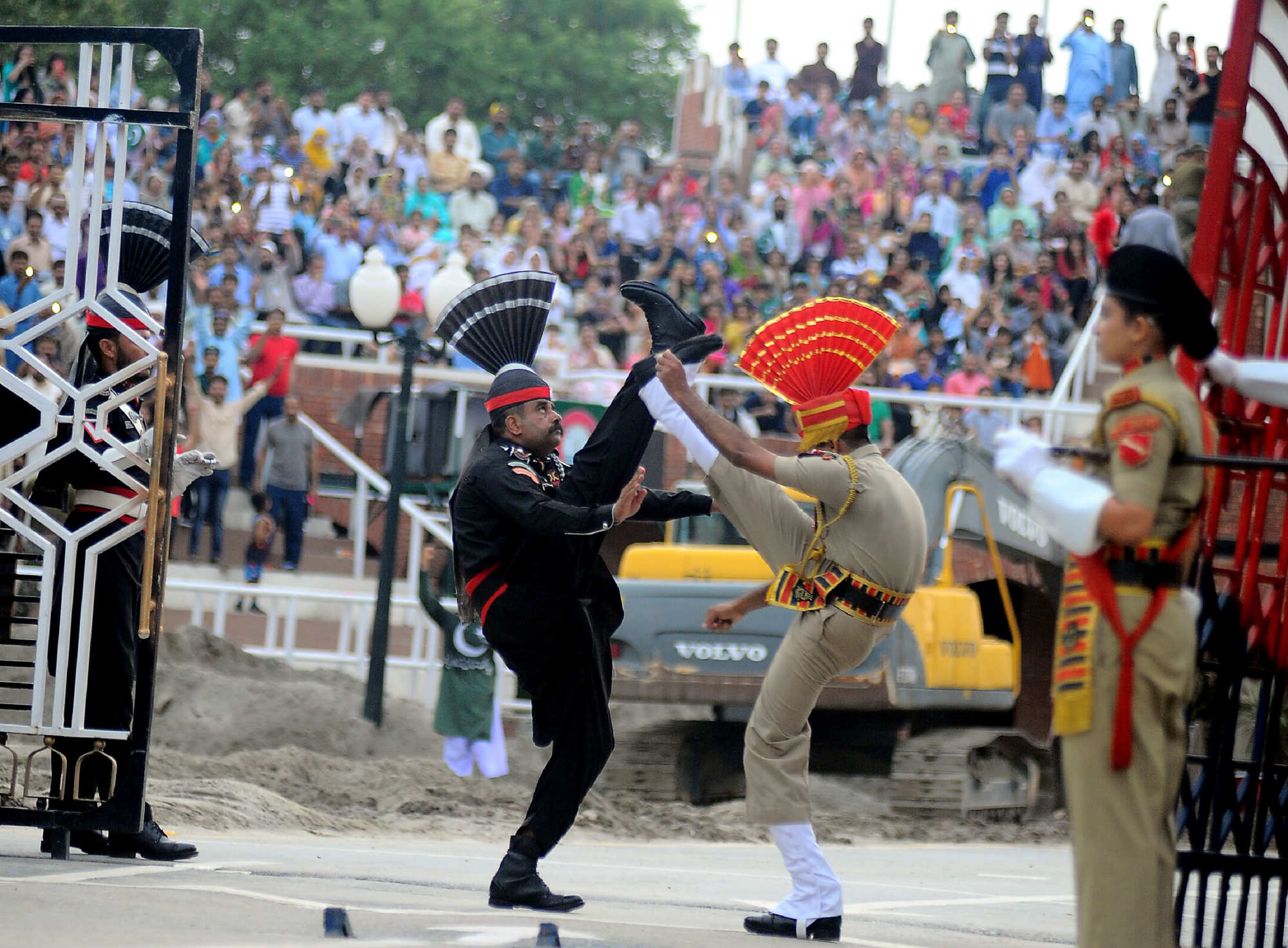 Indian (right) and Pakistani border guards take part in a nightly ceremony at the India-Pakistan border in Wagah on Aug. 2. From barbed grins in a carefully synchronised daily flag ceremony to murderous exchanges across barbed wire in Kashmir, the India-Pakistan border is a 70-year-old scar that will not heal. | AFP-JIJI