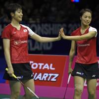 Japan\'s Yuki Fukushima (left) and Sayaka Hirota touch hands as they face China\'s Jia Yifan and Chen Qingchen in the women\'s doubles final at the World Badminton Championships on Sunday in Glasgow, Scotland. | AFP-JIJI