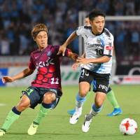 Ventforet\'s Yuki Horigome (left) and Frontale\'s Ryota Oshima compete during Sunday\'s match in Kofu. The teams settled for a 2-2 draw. | KYODO