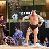 Yokozuna Harumafuji purifies the ring by tossing salt on it during Sunday\'s KITTE tournament. | KAZ NAGATSUKA