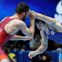 Yuki Takahashi competes with Thomas Gilman of the U.S. in the 57-kg final at the world wrestling championships on Friday in Paris. | REUTERS
