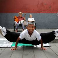 A man performs the splits while practicing kung fu in Beijing\'s Beihai Park on Sunday. | REUTERS