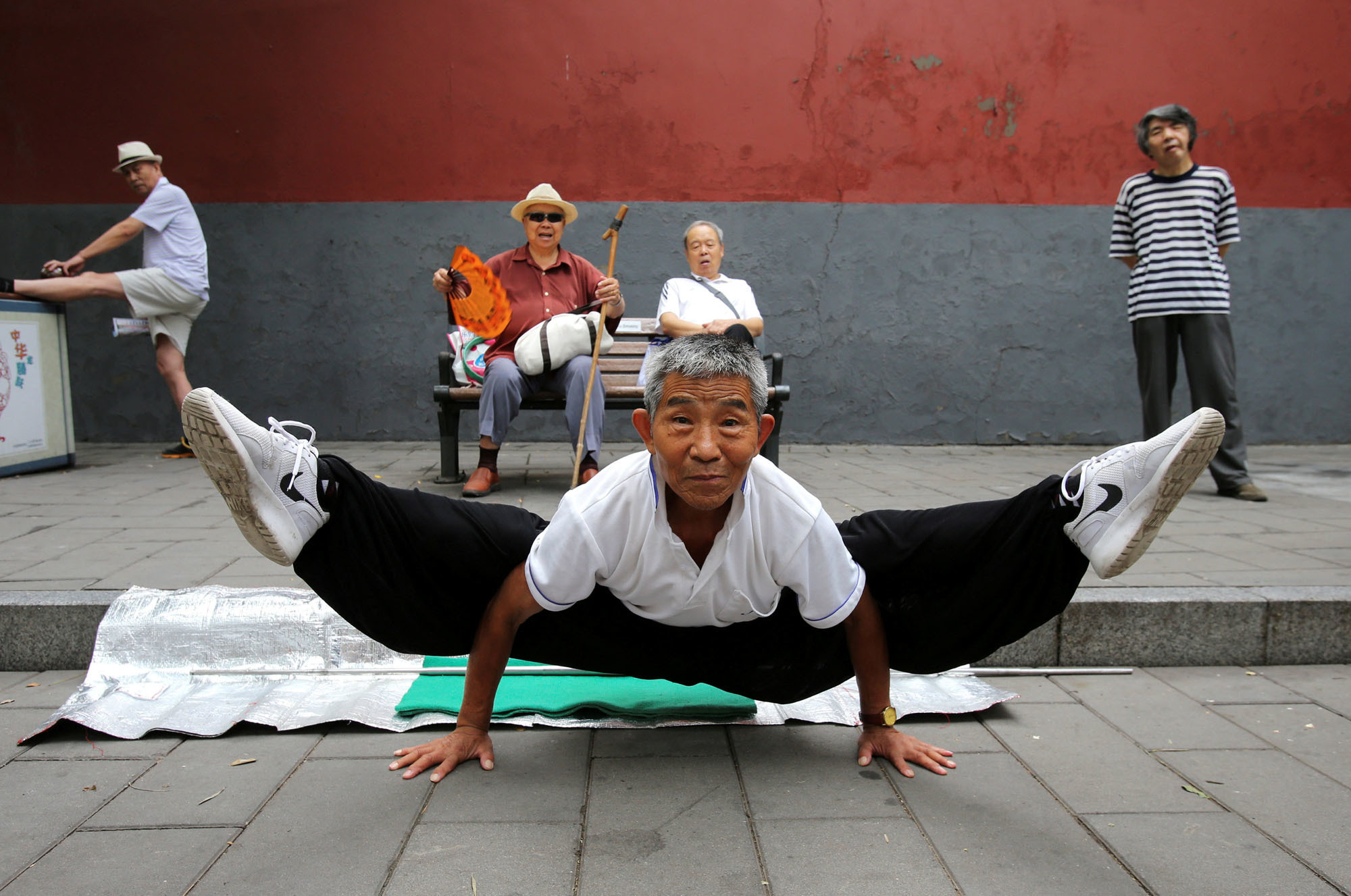 A man performs the splits while practicing kung fu in Beijing's Beihai Park on Sunday. | REUTERS