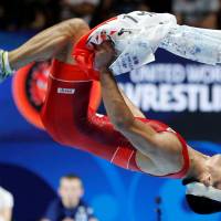 Kenichiro Fumita does a back flip in celebration after becoming Japan\'s first world-champion male wrestler in 34 years after beating Kazakhstan\'s Mirambek Ainagulov in the 59-kg final at the world championships in Paris on Tuesday. | REUTERS