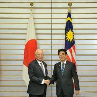 Malaysian Prime Minister Najib Razak  and Prime Minister Shinzo Abe shake hands following a bilateral summit meeting in Tokyo  on Nov. 16. | MINISTRY OF FOREIGN AFFAIRS, MALAYSIA