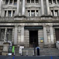 The Bank of Japan headquarters is seen in Tokyo. In an 8-1 vote, the central bank voted to maintain its target interest rates and asset-purchasing program. | SATOKO KAWASAKI
