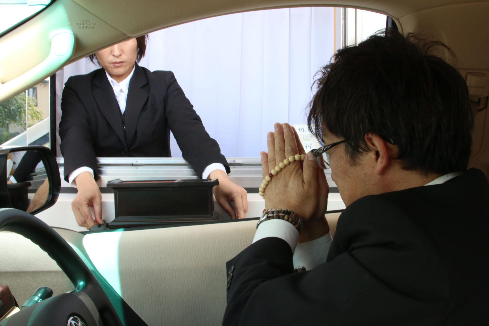 People demonstrate a drive-thru funeral service allowing the bereaved to give their final farewells from their car. | KANKON SOUSAI AICHI GROUP
