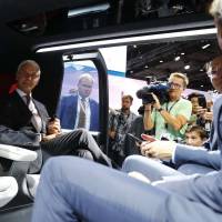 Volkswagen CEO Matthias Mueller sits in a Sedric self-driving electric vehicle during the opening of the Frankfurt auto show in Germany on Monday. | REUTERS