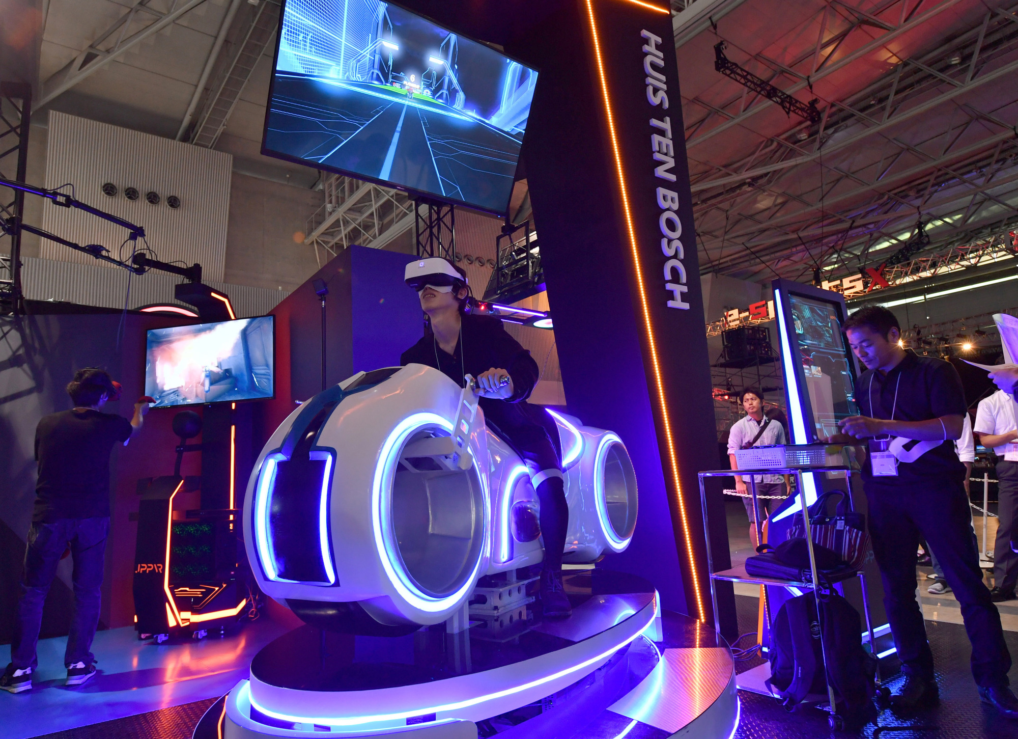A visitor tries out a virtual reality motorcycle attraction reminiscent of 'Tron' at a preview of the Tokyo Game Show on Thursday ahead of its official opening to the public this weekend. The attraction is the creation of Tokyo-based firm JPPVR technology. | YOSHIAKI MIURA