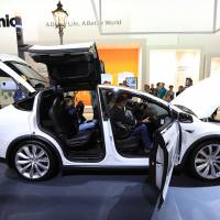 Visitors inspect a Tesla Co. Model X electric automobile, fitted with Panasonic batteries, on the Panasonic Corp. exhibition stand at the IFA Consumer electronics show in Berlin on Sept. 1. | BLOOMBERG