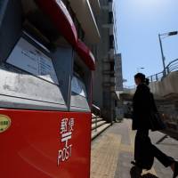 Japan Post Co. will raise shipping fees for its door-to-door parcel delivery service amid increasing labor costs. | BLOOMBERG