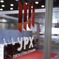 The Japan Exchange Group Inc. logo is displayed on a glass door at the Tokyo Stock Exchange on Aug. 30. Ahead of the Oct. 22 election, foreign investors have been pouring their money into Japanese stocks. | BLOOMBERG